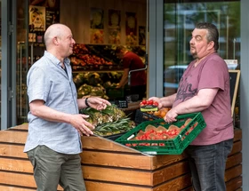 leerwerkburo-reintegratie-mannen-praten-voor-groentenwinkel