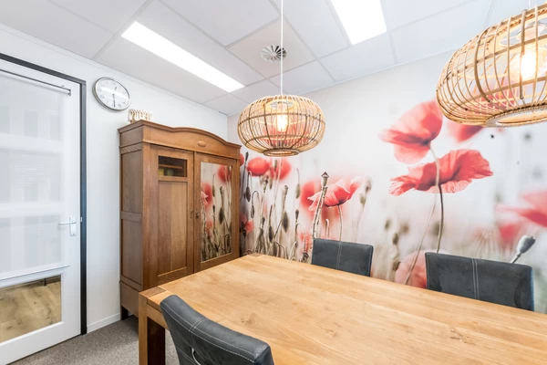 "leerwerkburo reintegratie coachruimte met tafel, stoelen en houten kast"