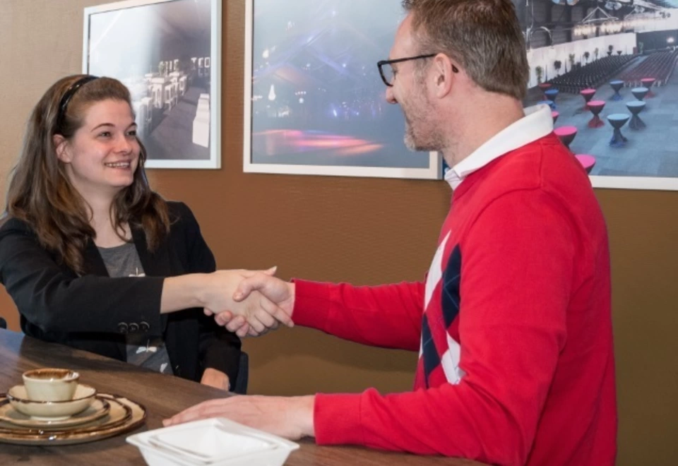 Laura wordt door haar werkgever gefeliciteerd met haar welverdiende contract.