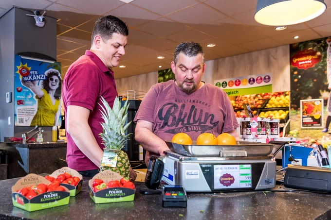 leerwerkburo-reintegratie-groentewinkel-twee-mannen-wegen-fruit-op-de-weegschaal
