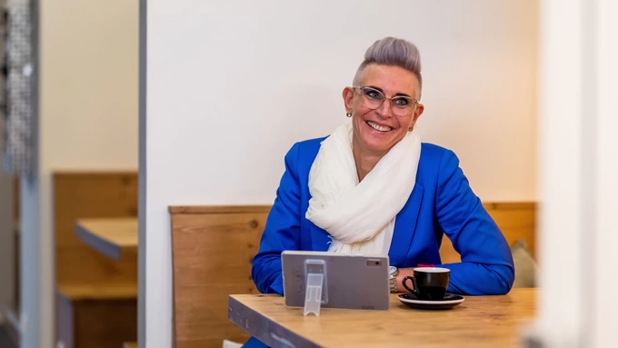 leerwerkburo-reintegratie-lachende-vrouw-aan-tafel-met-tablet