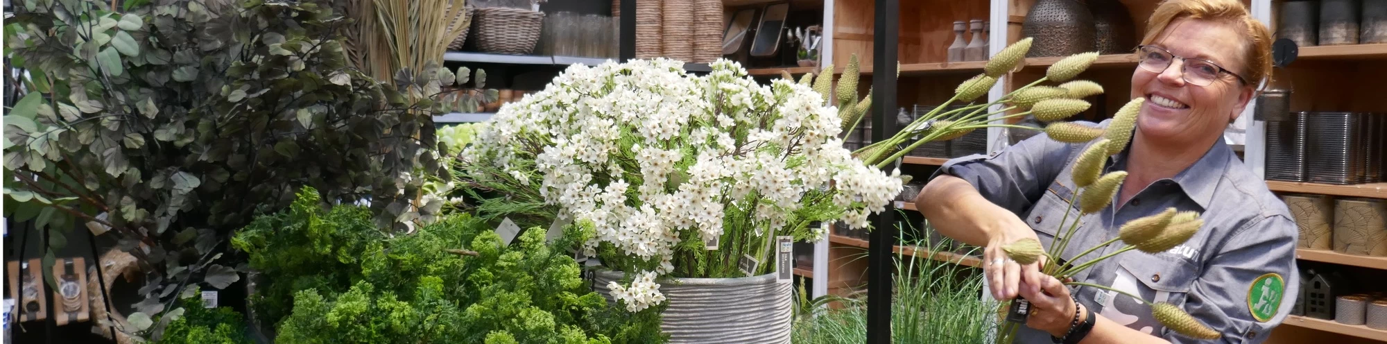 "leerwerkburo reintegratie vrouw schikt bloemen"