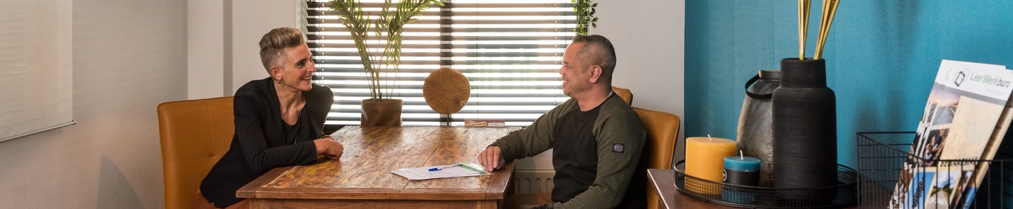 Leerwerkburo-reintegratie-man-en-vrouw-gesprek-aan-tafel