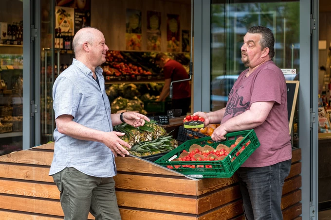 leerwerkburo-reintegratie-mannen-praten-voor-groentenwinkel