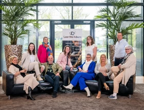 Leerwerkburo-reintegratie-team-personen-zittend-en-staand-rond-bank