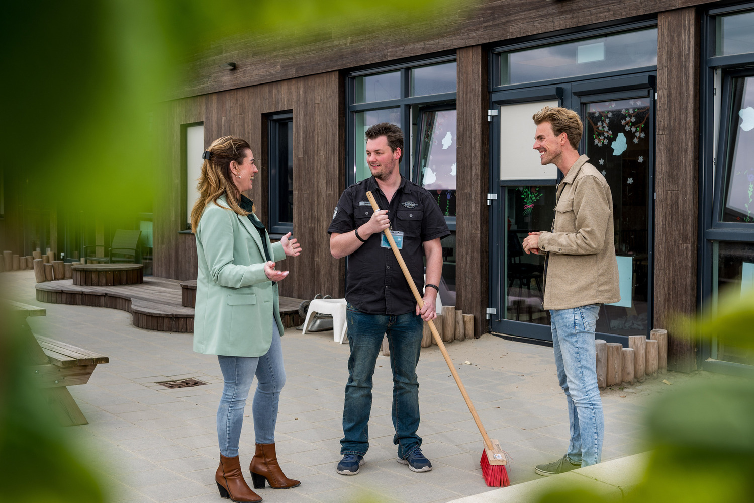 "leerwerkburo reintegratie drie mensen in gesprek op een schoolplein"