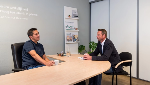 "leerwerkburo reintegratie twee mannen in kantoor in gesprek met elkaar"